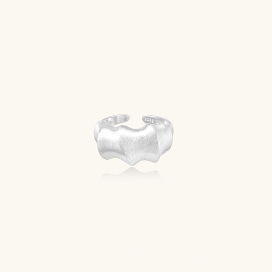 Brushed sterling silver ring with organic wave-like edges and adjustable cuff design on white background